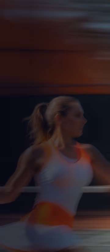 Žena igra tenis na sportskom terenu